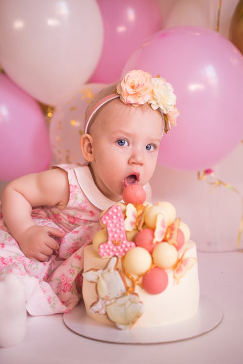 Baby in Pink Floral Dress and Birthday Cake