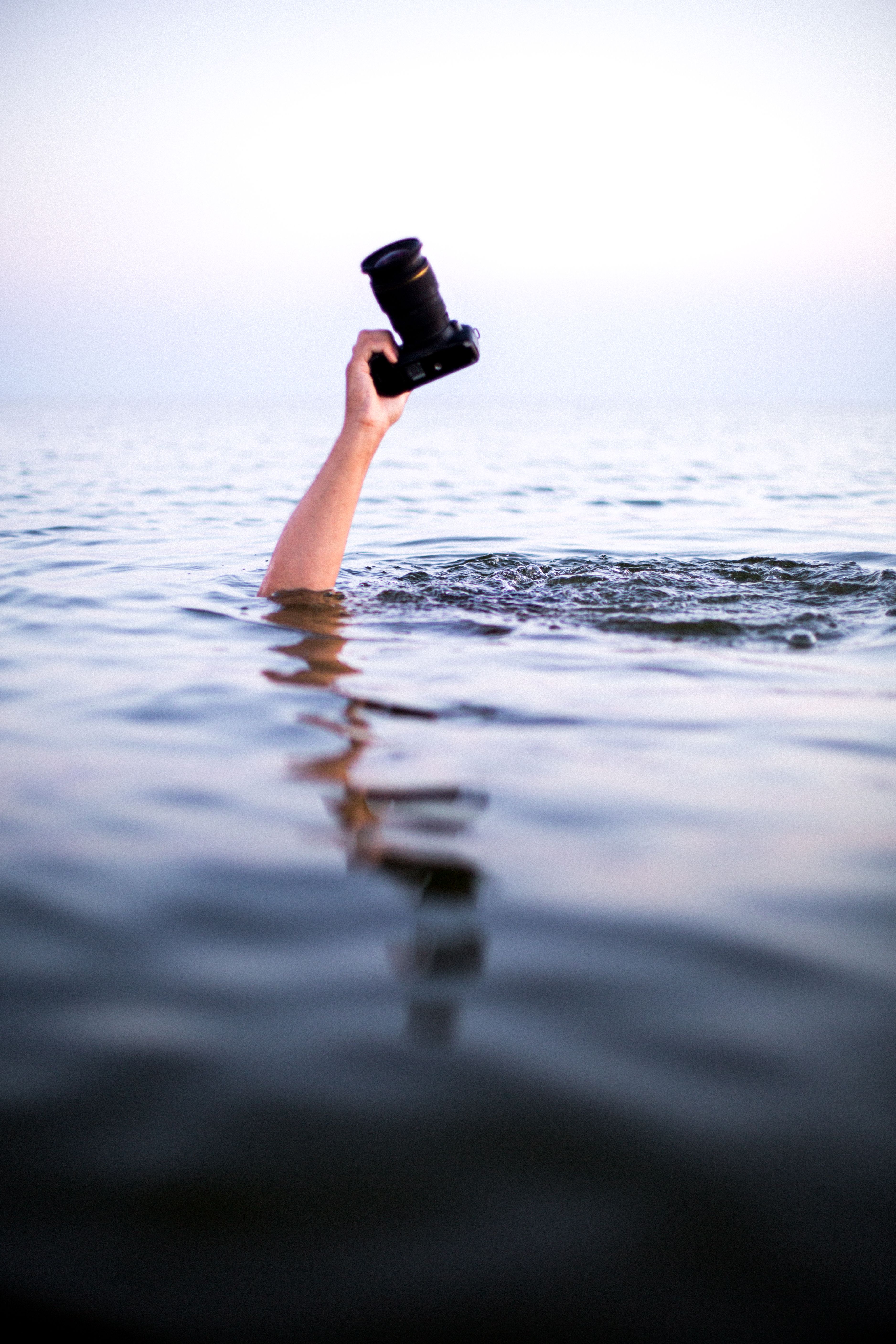 Hand Holding Camera over Water · Free Stock Photo