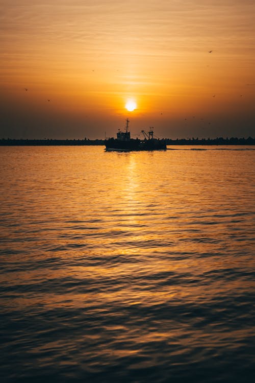 Free Silhouette of Ship on Sea during Sunset Stock Photo