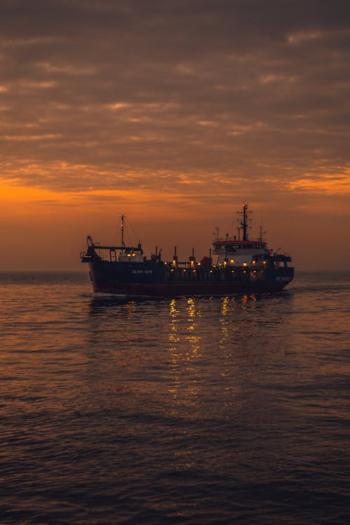 Ship Sailing in Sea at Sunset 