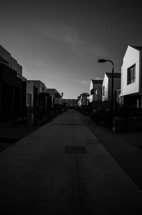 Free A dramatic black and white view of a suburban street with modern houses. Stock Photo