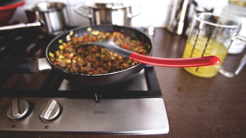 Free Dish Cooking on Black Non Stick Pan on a Burner Stock Photo