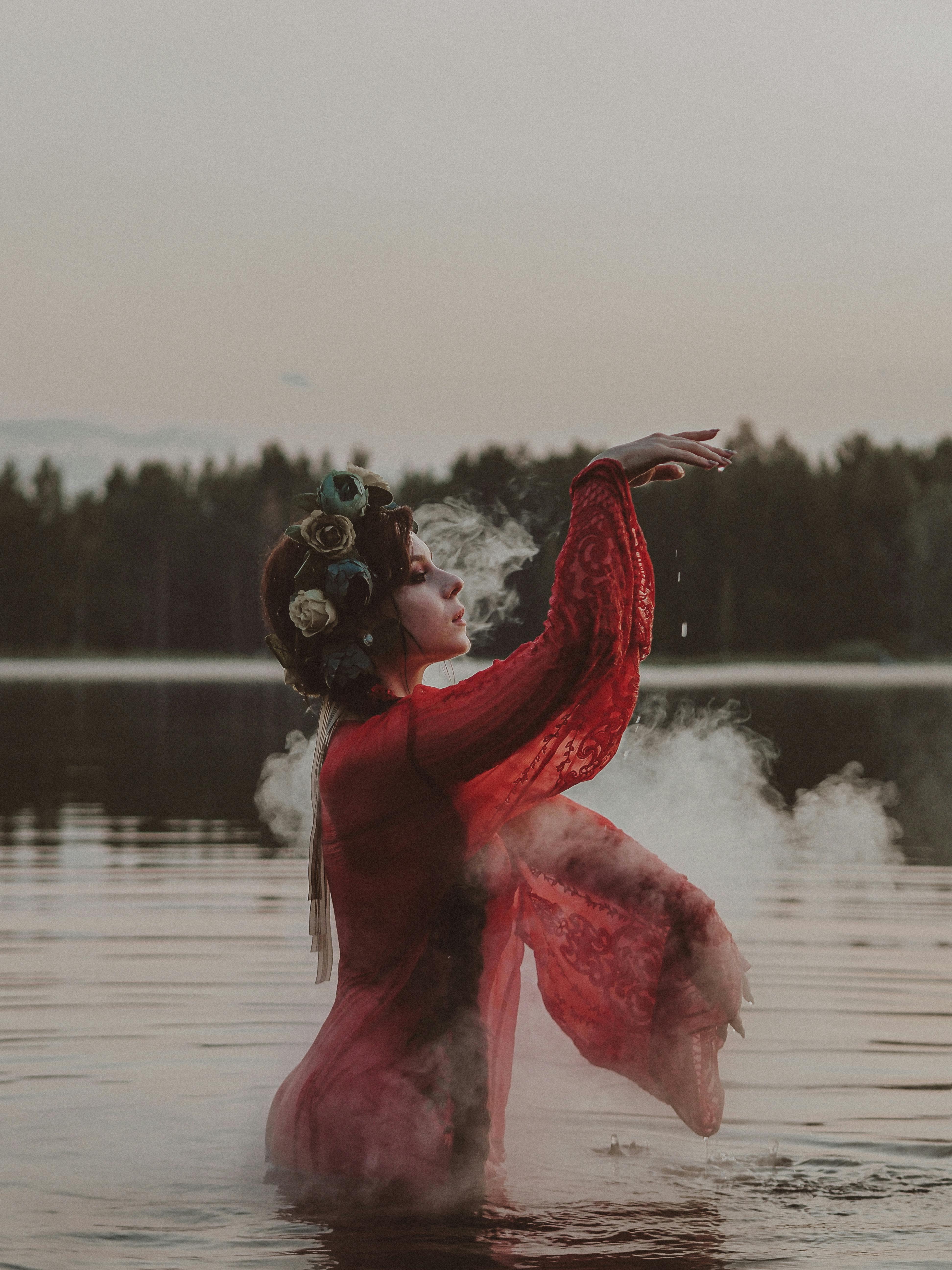 woman in red long sleeve dress standing on water