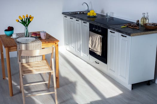 A bright and cozy kitchen featuring wooden furniture and kitchen essentials.