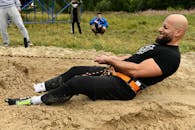A Bearded Man Pulling a Rope attached to His Harness