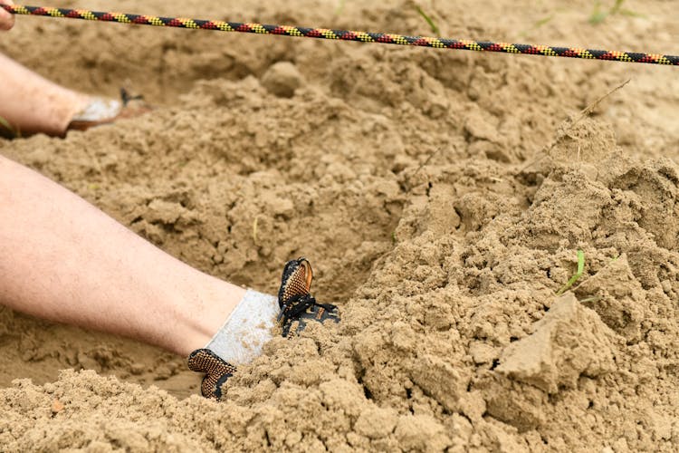 
A Person's Feet Buried In Sand