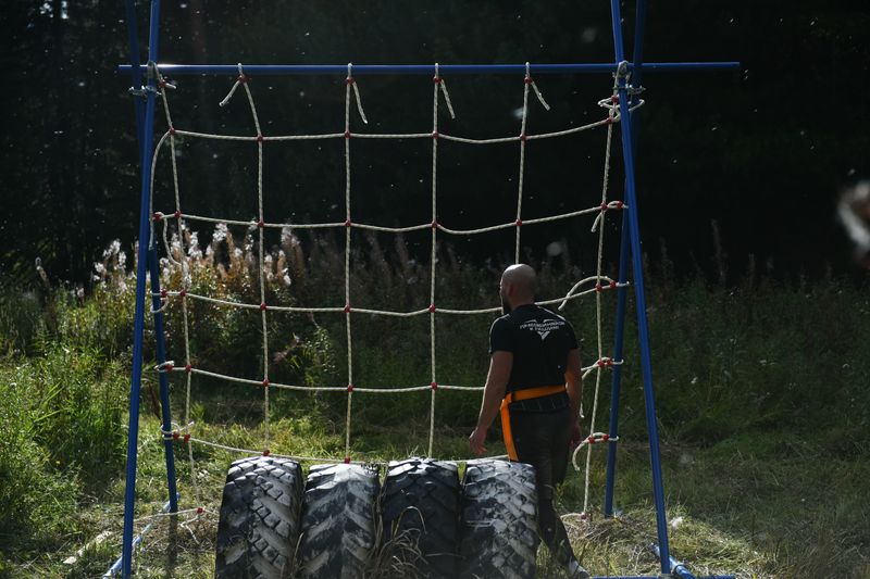 Training on an outdoor obstacle course with a net and tyres
