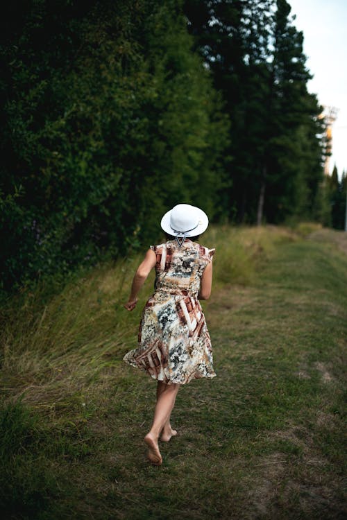 Woman Wearing White Hat Running in the Field