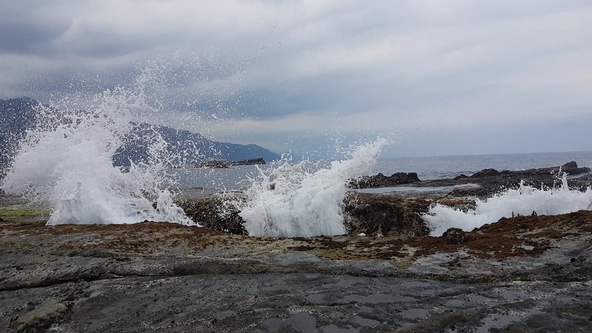 Yogurt bowl being topped with granola and berries as a macro-friendly breakfast