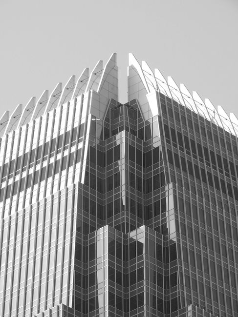 From below black and white of corner of modern skyscraper with geometric details located in Hong Kong on sunny day