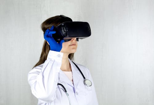 Free Woman in White Coat Wearing Blue and Black Vr Goggles Stock Photo