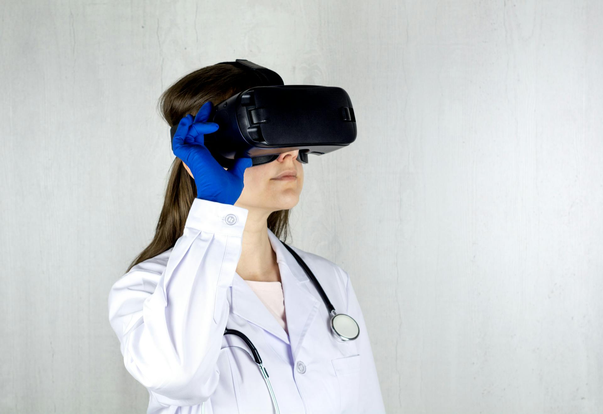 Doctor in a lab coat exploring virtual reality technology with goggles.