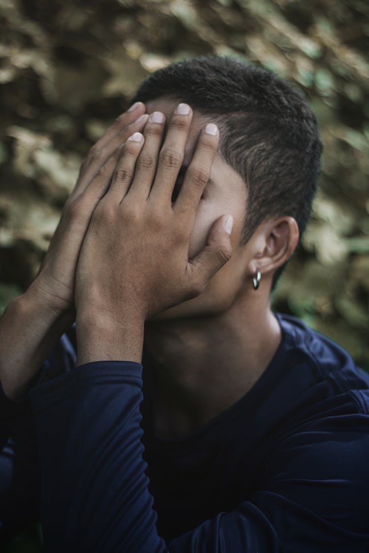 Man In Blue Crew Neck Shirt Covering Face With His Hands