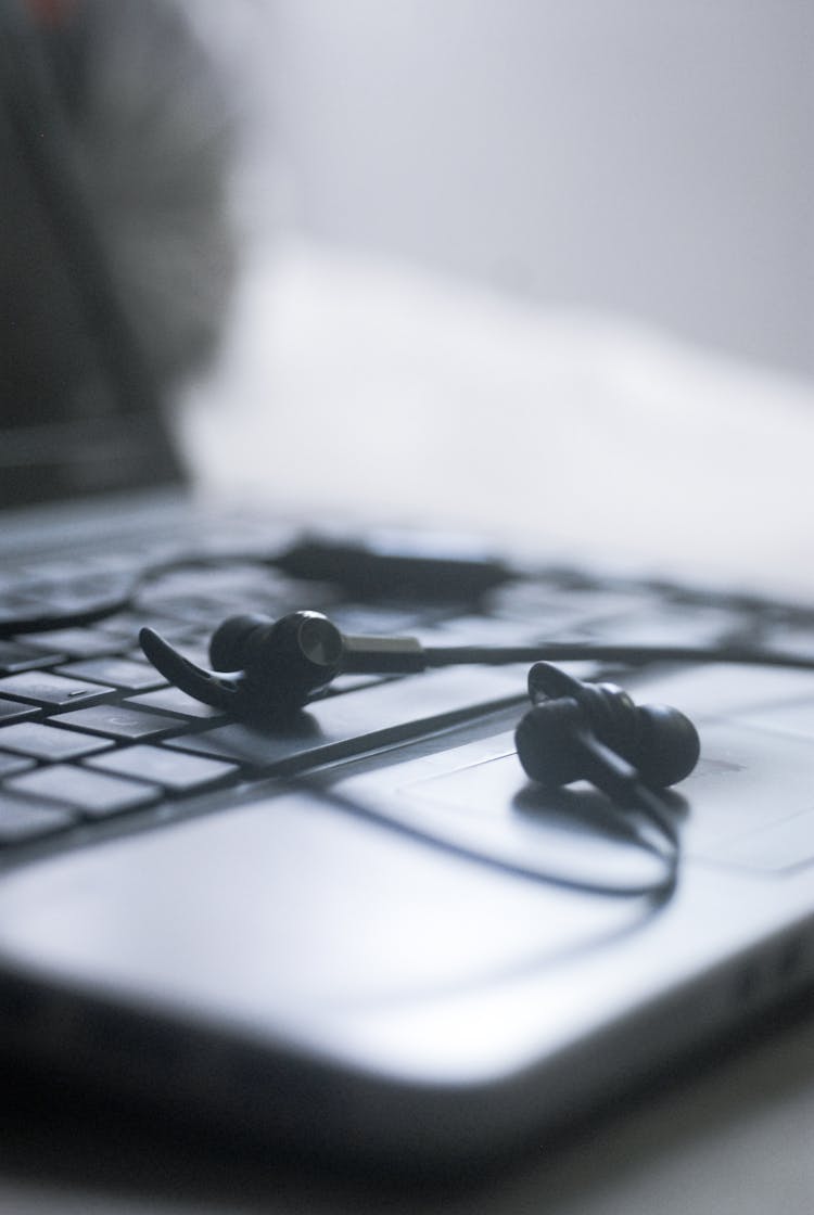 Black Earphone On Black Laptop