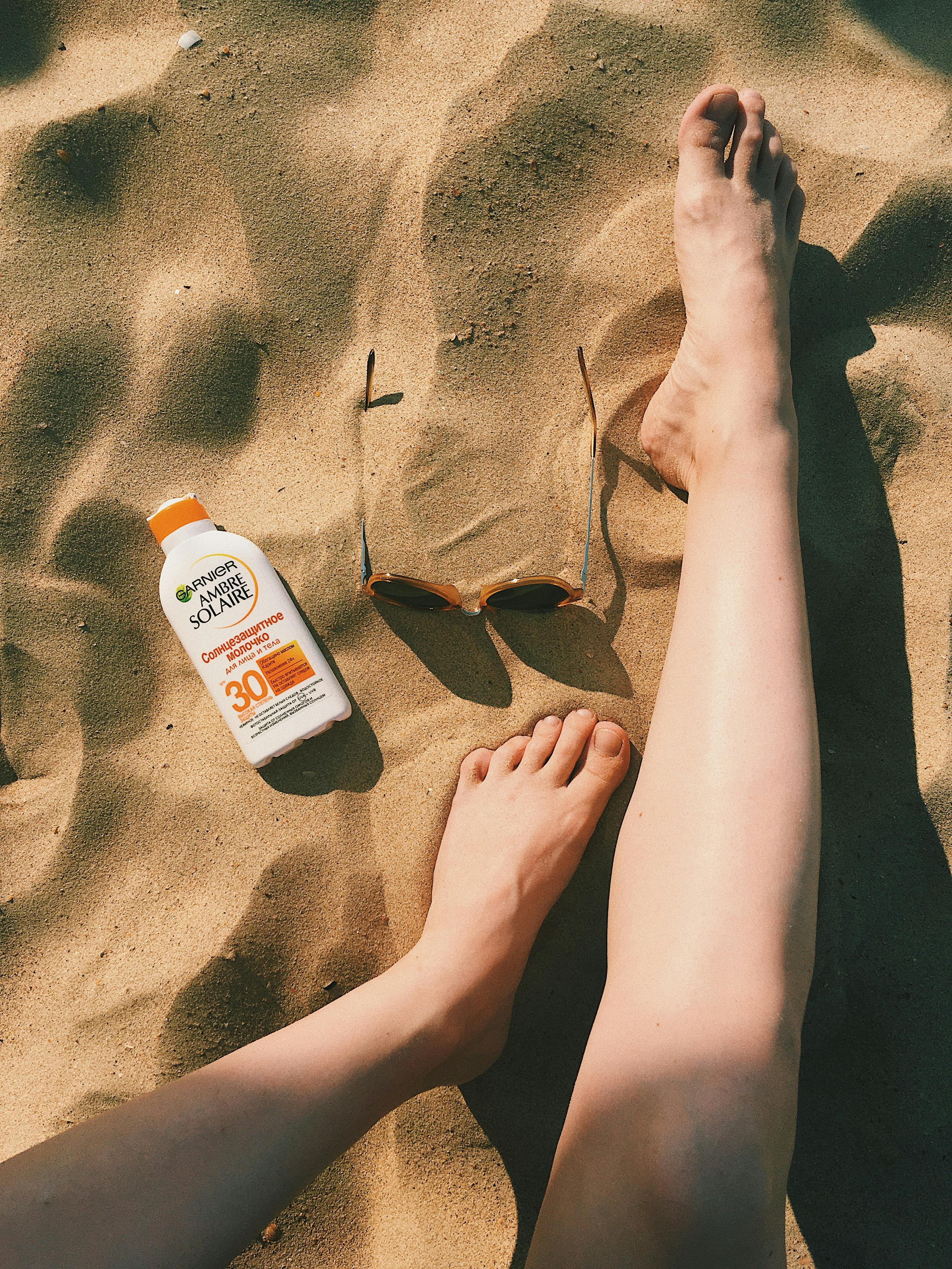 persons feet on brown sand