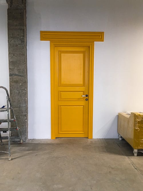 Free Yellow Wooden Door on White Wall Stock Photo