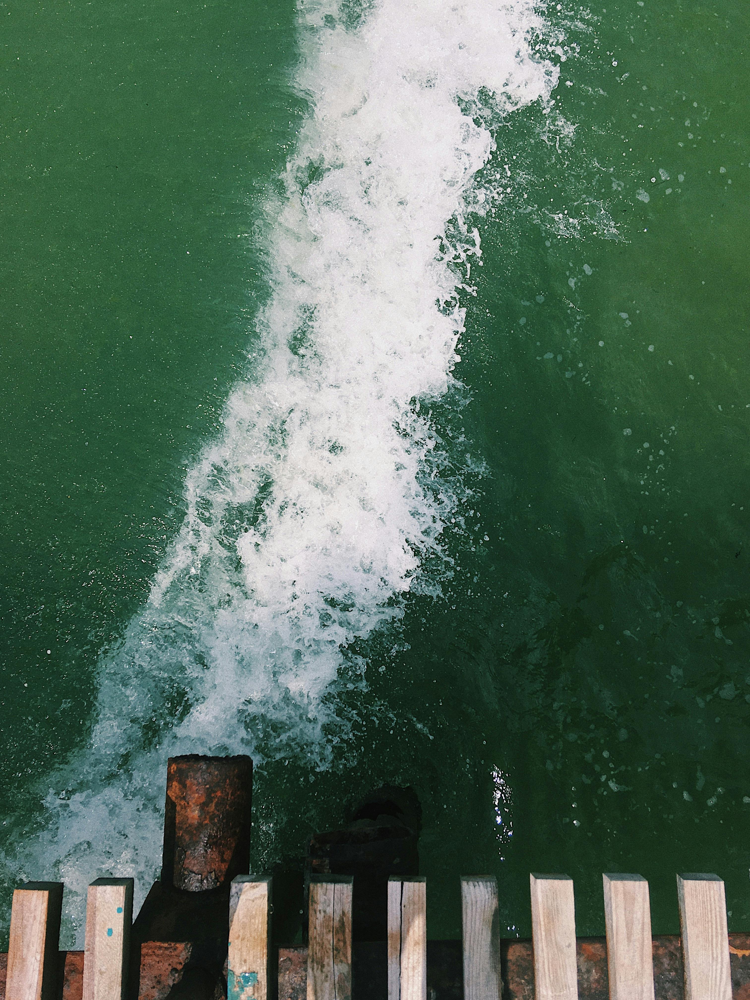 A dramatic view of waves splashing near a wooden pier in Anapa, Russia.
