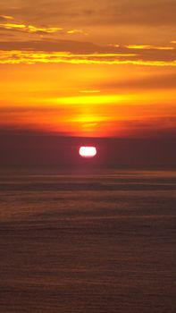Captivating sunset over the ocean with orange hues and serene water reflections.