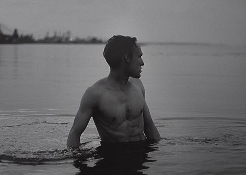 Free Artistic black and white portrait of a shirtless man in a serene body of water. Stock Photo
