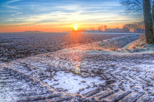 A breathtaking frosty field during sunrise, showcasing winter's beauty.