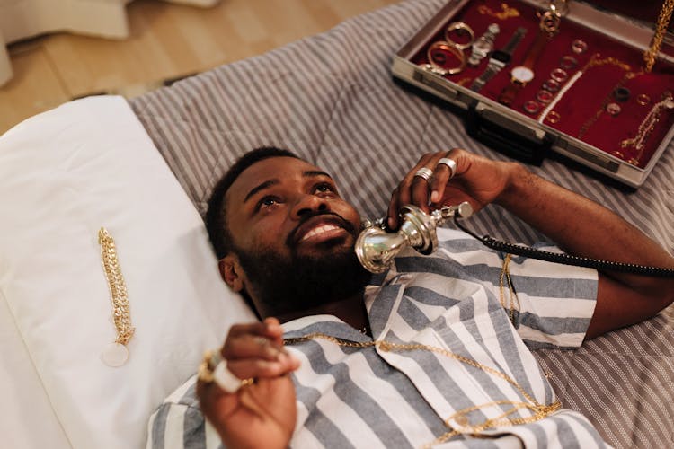 Man Talking On The Phone While Lying On Bed