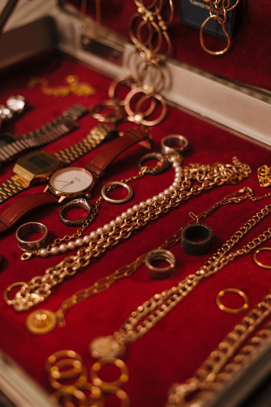Gold chains, rings and pearl jewelry stored in a red velvet jewelry case