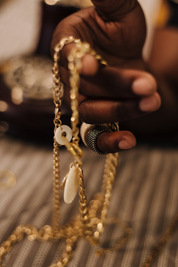 Close-up Of A Hand Holding A Gold Necklace