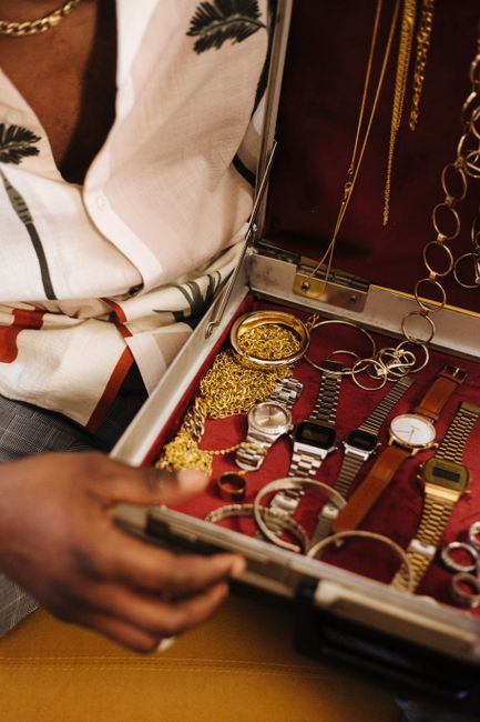 An open briefcase showing an assortment of gold and silver jewelry and wristwatches, the kind of valuables an insurance inventory should capture in detail