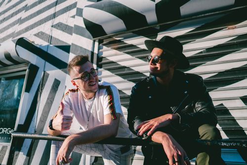 Free Two stylish friends enjoying a sunny day, expressing bond and friendship on a vibrant street. Stock Photo