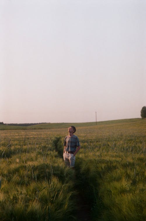 A Man Standing on Green Grass Field