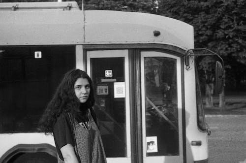 A Woman Standing Beside the Bus