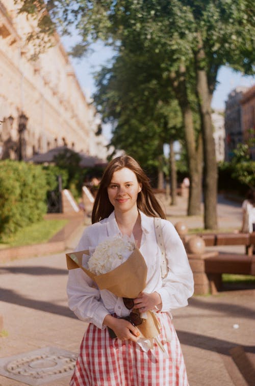 
A Woman Holding a Bouquet of White Flowers