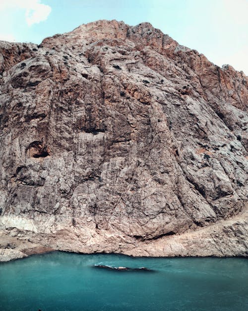 Free Drone Shot of a Rock Formation near a Body of Water Stock Photo