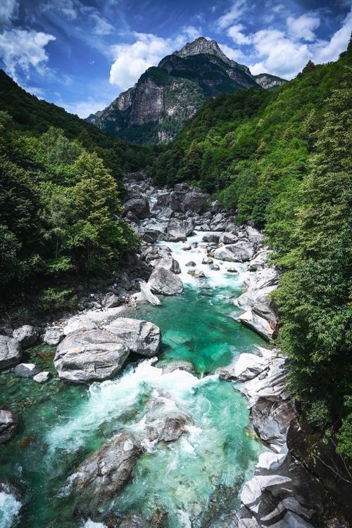 Free A stunning aerial view of a turquoise river flowing through a lush green mountain landscape. Stock Photo