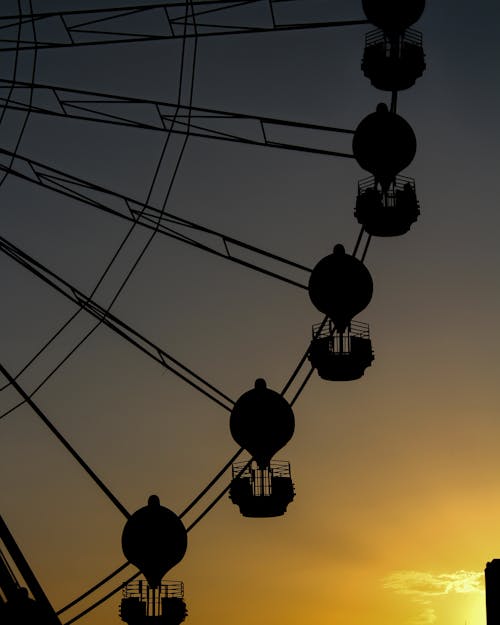 A Silhouette of a Ferris Wheel during the Golden Hour