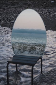 An artistic mirror reflecting ocean waves on the beach, creating a surreal and enchanting scene.