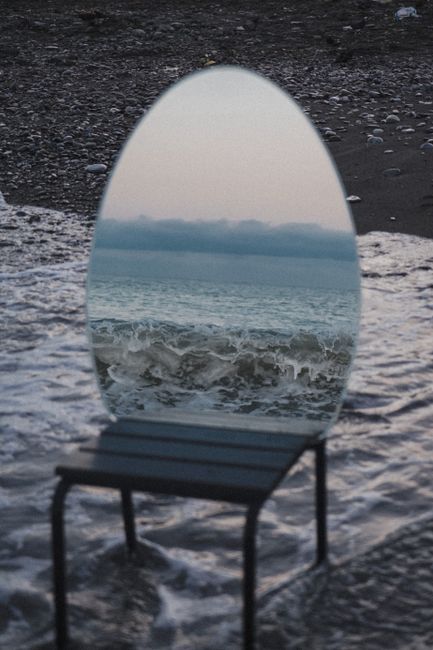 An artistic mirror reflecting ocean waves on the beach, creating a surreal and enchanting scene.