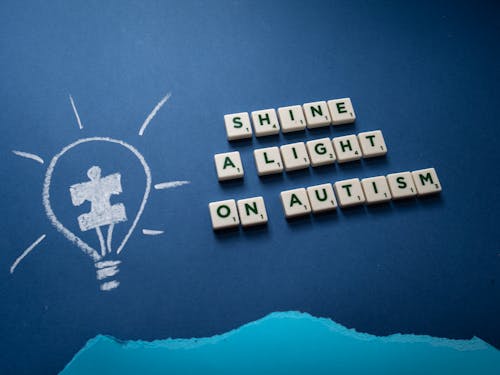 Free A Slogan on Autism Spelled on Scrabble Tiles with a Light Bulb Drawing Stock Photo