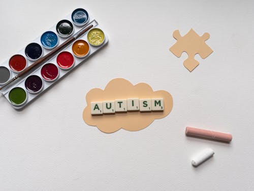 Art Materials and Scrabble Tiles on Paper Cutouts on White Surface