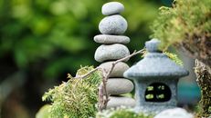 Zen stone stack in a lush garden, symbolizing balance and tranquility.