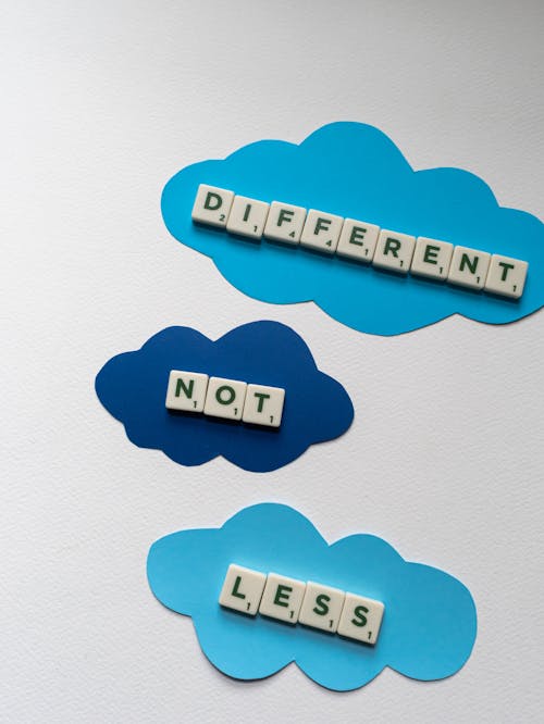 Free A Slogan Different Not Less Spelled on Scrabble Tiles  Stock Photo