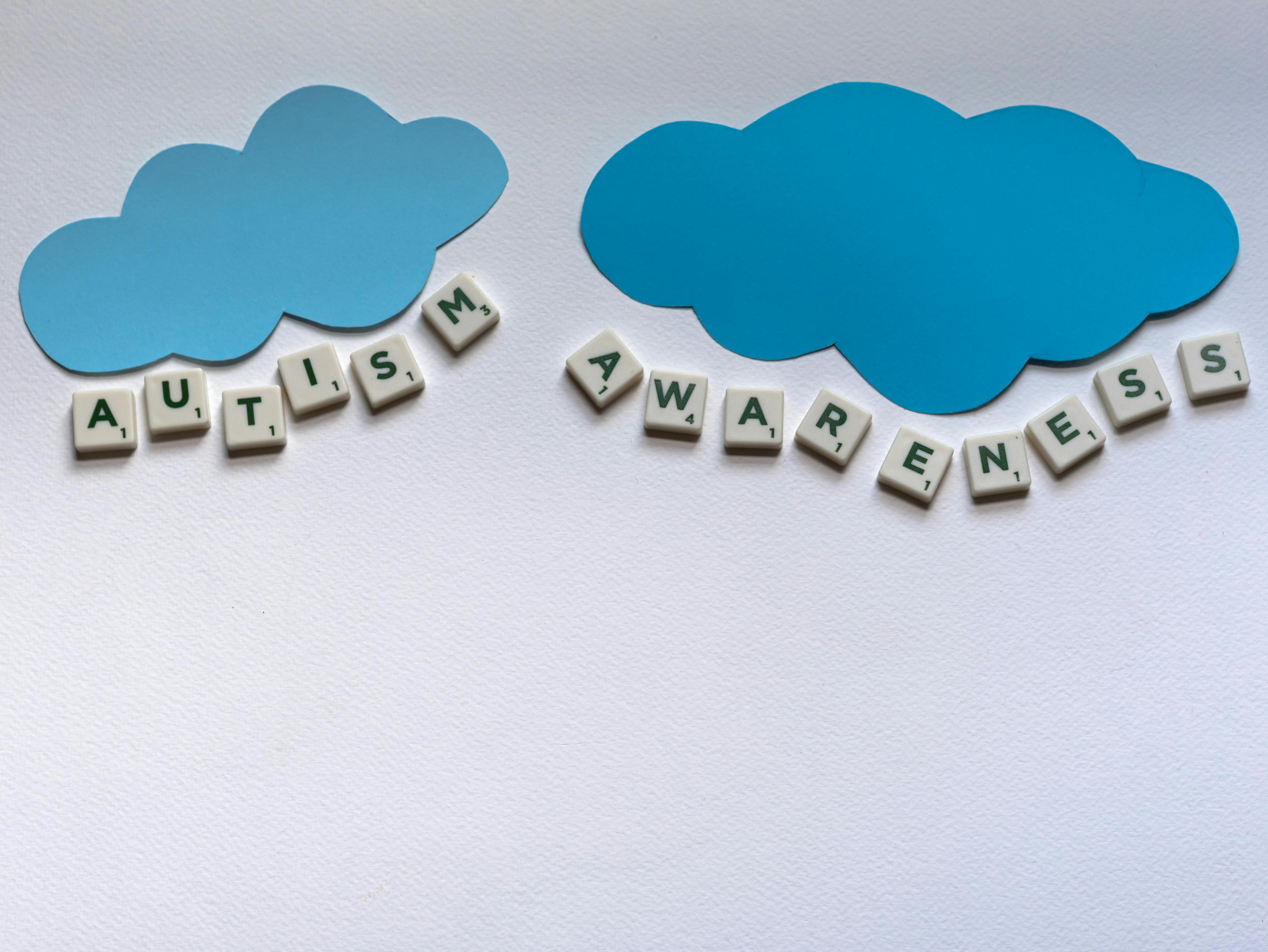 Promote autism awareness with scrabble tiles and blue clouds in a still life setup.