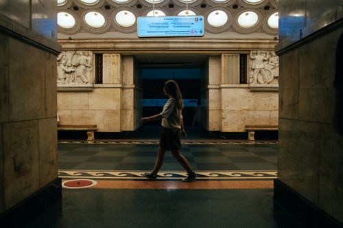 Free A woman walks through a historic Moscow subway station, capturing the ornate interior details. Stock Photo