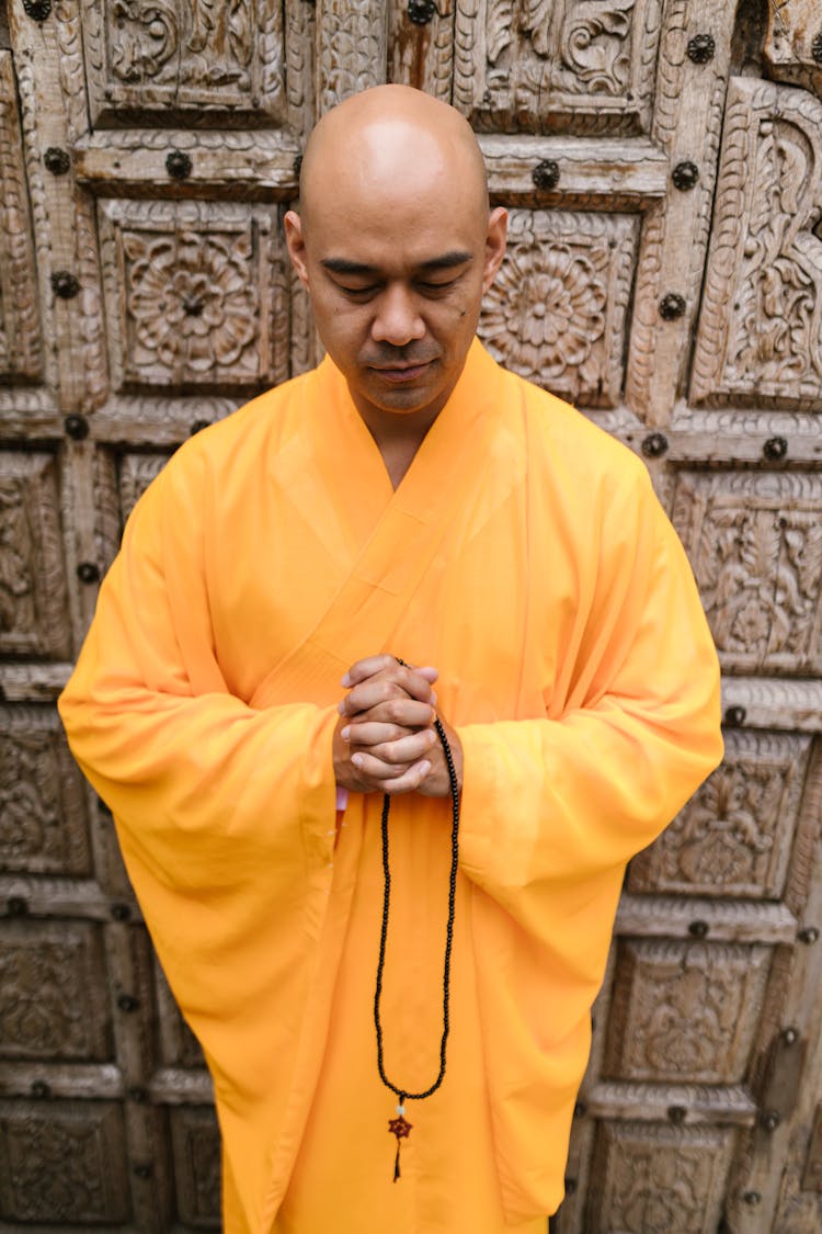 A Monk In Yellow Robe Praying