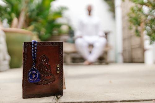 Tibetan Notebook in Leather Cover and Amulet on Table