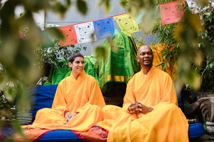 Men In Orange Robes Sitting In A Chair