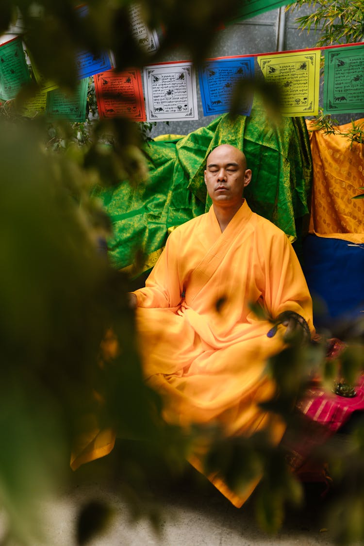 Monk Closing His Eyes Meditating In Yellow Robe