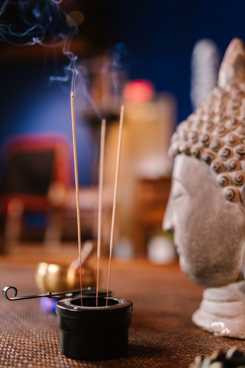 Free Close-up of incense and Buddha statue in a tranquil setting, perfect for meditation themes. Stock Photo