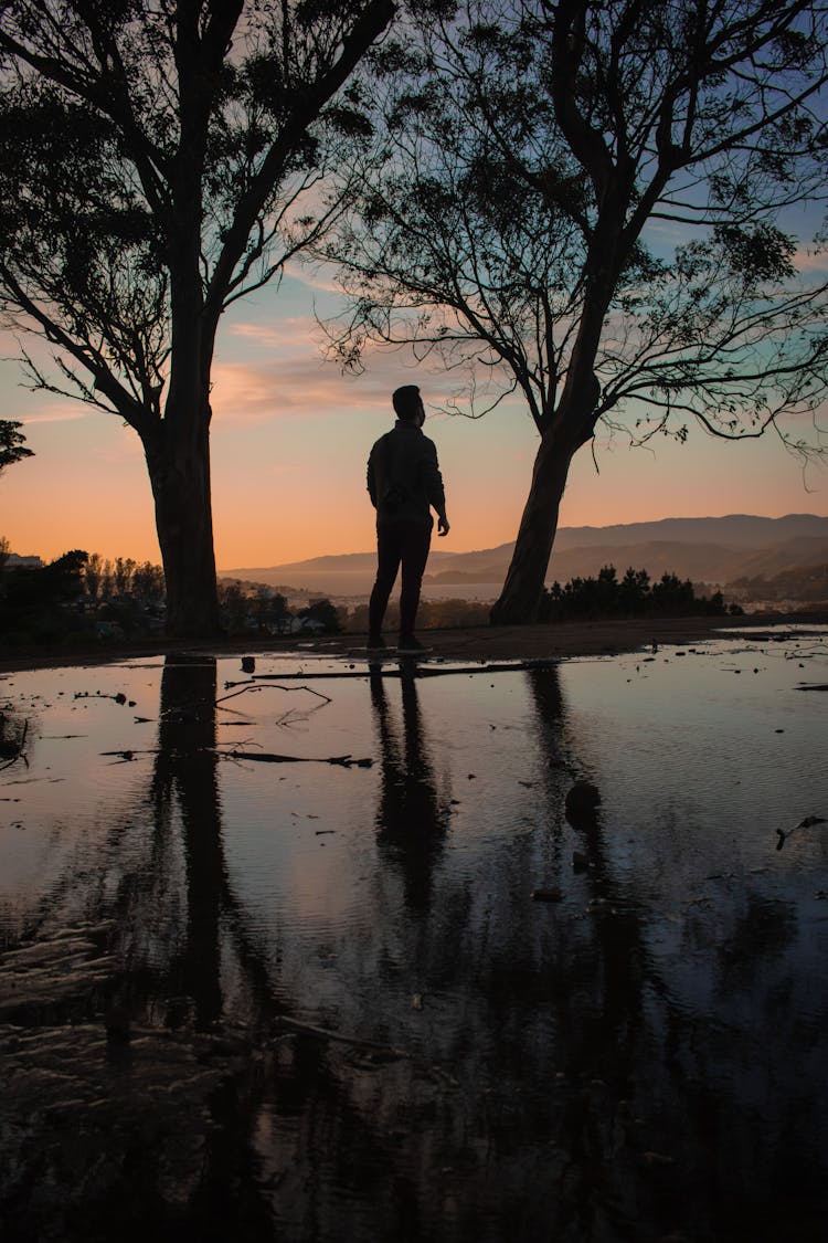 Silhouette Of Hiker In Mountains At Sunrise