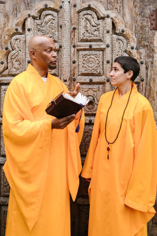 Free Two Buddhist monks in traditional robes converse outdoors, embodying serenity and spirituality. Stock Photo